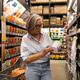 Middle-aged woman shopping for household products in a well-organized store aisle during the daytime Middle-aged woman shopping for household products in a well-organized store aisle during the daytime - PhotoDune Item for Sale