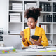 A woman in a yellow jacket is smiling and holding a calculator A woman in a yellow jacket is smiling and holding a calculator - PhotoDune Item for Sale