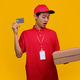 Surprised Courier in Red Uniform Looking at Cardboard Boxes while Holding Credit Card Surprised Courier in Red Uniform Looking at Cardboard Boxes while Holding Credit Card - PhotoDune Item for Sale