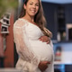 Pregnant woman smiling warmly in a kitchen setting wearing a white dress Pregnant woman smiling warmly in a kitchen setting wearing a white dress - PhotoDune Item for Sale