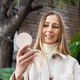 Young woman smiling while looking into a compact mirror outdoors Young woman smiling while looking into a compact mirror outdoors - PhotoDune Item for Sale
