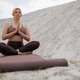 Meditating woman sitting cross-legged in nature with closed eyes Meditating woman sitting cross-legged in nature with closed eyes - PhotoDune Item for Sale