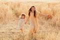 Two sisters little girls wear casual dresses having fun in wheat field. Kids in motion. Yellow color Two sisters little girls wear casual dresses having fun in wheat field. Kids in motion. Yellow color - PhotoDune Item for Sale