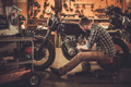 Mechanic building vintage style cafe-racer motorcycle in custom garage Mechanic building vintage style cafe-racer motorcycle in custom garage - PhotoDune Item for Sale