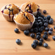 Three Homemade Blueberry Muffins with Scattered Fresh Blueberries on Wooden Table, Vertical Three Homemade Blueberry Muffins with Scattered Fresh Blueberries on Wooden Table, Vertical - PhotoDune Item for Sale
