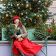 A woman in a red clothes with a bouquet of fir branches walks along the Christmas decorated streets A woman in a red clothes with a bouquet of fir branches walks along the Christmas decorated streets - PhotoDune Item for Sale