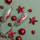 Champagne Flutes and Red Christmas Decorations on Green Background Champagne Flutes and Red Christmas Decorations on Green Background - PhotoDune Item for Sale