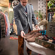 Fashionable man choosing old fashioned vintage leather shoes from display in second hand store. Fashionable man choosing old fashioned vintage leather shoes from display in second hand store. - PhotoDune Item for Sale