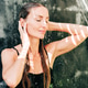 Pretty caucasian woman takes a tropical shower outside in summer. Pretty caucasian woman takes a tropical shower outside in summer. - PhotoDune Item for Sale