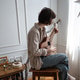 Young female musician playing melody on small ukulele guitar at home in cozy living room on weekend. Young female musician playing melody on small ukulele guitar at home in cozy living room on weekend. - PhotoDune Item for Sale