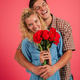 Joyful couple happily embracing each other while holding a beautiful bouquet of vibrant red roses Joyful couple happily embracing each other while holding a beautiful bouquet of vibrant red roses - PhotoDune Item for Sale