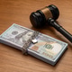 A judge's gavel next to a stack of money bound by a metal chain and secured with a padlock. A judge's gavel next to a stack of money bound by a metal chain and secured with a padlock. - PhotoDune Item for Sale
