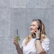 A blonde woman drinks a mojito and talks on the phone in the city in summer. A blonde woman drinks a mojito and talks on the phone in the city in summer. - PhotoDune Item for Sale
