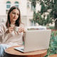 A woman is sitting in a coffee shop drinking coffee and using a laptop. A woman is sitting in a coffee shop drinking coffee and using a laptop. - PhotoDune Item for Sale