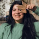 Smiling Venezuelan woman standing under the sun in the park, covering her face with a dry leaf Smiling Venezuelan woman standing under the sun in the park, covering her face with a dry leaf - PhotoDune Item for Sale