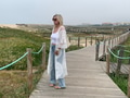 A woman on a worn wooden boardwalk in trendy jeans and white flowing cover up. A woman on a worn wooden boardwalk in trendy jeans and white flowing cover up. - PhotoDune Item for Sale