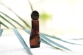 Blank amber glass essential oil bottle on tropical leaf background Blank amber glass essential oil bottle on tropical leaf background - PhotoDune Item for Sale
