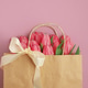 Gift Bag with Pink Tulips on Pink Background. Valentine's or Mother's Day Celebration Gift Bag with Pink Tulips on Pink Background. Valentine's or Mother's Day Celebration - PhotoDune Item for Sale