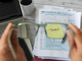Person holding eye glasses focusing on the word Taxes written on tax forms while filing tax return Person holding eye glasses focusing on the word Taxes written on tax forms while filing tax return - PhotoDune Item for Sale