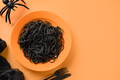 Halloween Italian black pasta decorated funny spiders in orange plate on orange . Halloween Italian black pasta decorated funny spiders in orange plate on orange . - PhotoDune Item for Sale