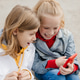 Preteen friends boy and girl play smartphone gadget. Preteen friends boy and girl play smartphone gadget. - PhotoDune Item for Sale
