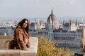 Portrait of beautiful young woman on balcony overlooking Hungarian Parliament in Budapest, Hungary Portrait of beautiful young woman on balcony overlooking Hungarian Parliament in Budapest, Hungary - PhotoDune Item for Sale