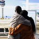 Black couple sharing romantic embrace in airport terminal lounge Black couple sharing romantic embrace in airport terminal lounge - PhotoDune Item for Sale