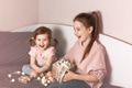 Two little girls sisters sitting on bed with gift boxes and laughing. Sincere moments Two little girls sisters sitting on bed with gift boxes and laughing. Sincere moments - PhotoDune Item for Sale