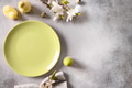 Easter festive table setting with gray plate, spring flowers and green colorful eggs. Easter festive table setting with gray plate, spring flowers and green colorful eggs. - PhotoDune Item for Sale