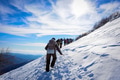 Group of mountain hikers in single file go up the snowy peak. Group of mountain hikers in single file go up the snowy peak. - PhotoDune Item for Sale