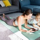 Woman and young girl lying on yoga mat at home looking at smartphone Woman and young girl lying on yoga mat at home looking at smartphone - PhotoDune Item for Sale
