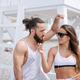 Young couple listening to music using one headphones on beach Young couple listening to music using one headphones on beach - PhotoDune Item for Sale