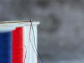 Sewing thread in United States colors through the eye of the needle closeup view with copy space Sewing thread in United States colors through the eye of the needle closeup view with copy space - PhotoDune Item for Sale