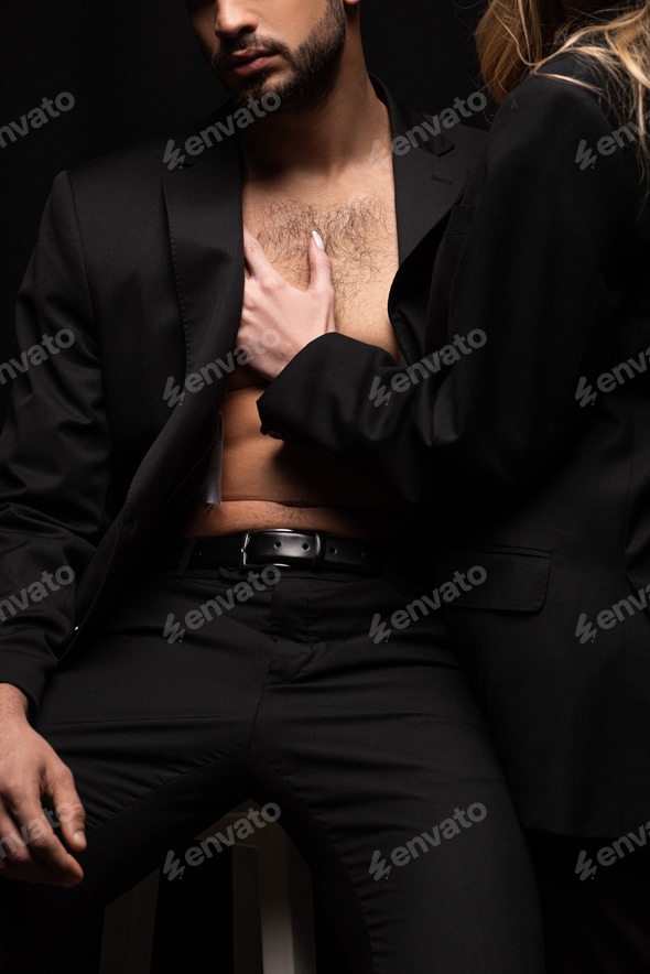 cropped view of young woman touching sexy man in suit sitting on chair isolated on black Stock Photo by LightFieldStudios cropped view of young woman touching sexy man in suit sitting on chair isolated on black Stock Photo by LightFieldStudios