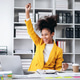 A woman in a yellow jacket is celebrating with her hands in the air A woman in a yellow jacket is celebrating with her hands in the air - PhotoDune Item for Sale