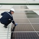 Worker cleans solar panels on rooftop during bright day for better energy efficiency Worker cleans solar panels on rooftop during bright day for better energy efficiency - PhotoDune Item for Sale