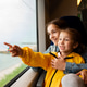 Two sister girls look out the window of a train at the sea. Two sister girls look out the window of a train at the sea. - PhotoDune Item for Sale