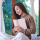 Portrait image of a woman with closed eyes holding and reading a book on the bed at home Portrait image of a woman with closed eyes holding and reading a book on the bed at home - PhotoDune Item for Sale