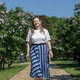 A blonde woman stands near blooming lilacs in a city park. Summer. A blonde woman stands near blooming lilacs in a city park. Summer. - PhotoDune Item for Sale