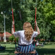 A blonde woman swinging on a swing in a park. Concept of freedom and happiness. Summertime. A blonde woman swinging on a swing in a park. Concept of freedom and happiness. Summertime. - PhotoDune Item for Sale