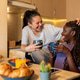 Lesbian couple enjoying breakfast and beverages at home Lesbian couple enjoying breakfast and beverages at home - PhotoDune Item for Sale
