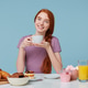 girl sitting at a table with slightly bowed head, smiles holds white cup with delicious drink girl sitting at a table with slightly bowed head, smiles holds white cup with delicious drink - PhotoDune Item for Sale