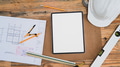 Above view digital tablet, blueprints and hard hat on wooden table. Above view digital tablet, blueprints and hard hat on wooden table. - PhotoDune Item for Sale