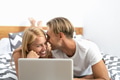 Happy couple lying on bed while using laptop computer - Happy people having funny bed time Happy couple lying on bed while using laptop computer - Happy people having funny bed time - PhotoDune Item for Sale