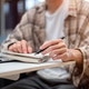 Close up of a man holding fountain pen writing in notebook over laptop sitting at cafe's white table Close up of a man holding fountain pen writing in notebook over laptop sitting at cafe's white table - PhotoDune Item for Sale