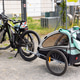 Parked bicycle attached child trailer stands on gravel near industrial fence Parked bicycle attached child trailer stands on gravel near industrial fence - PhotoDune Item for Sale