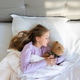 Young girl sleeping in bed while hugging a stuffed bear in natural light Young girl sleeping in bed while hugging a stuffed bear in natural light - PhotoDune Item for Sale
