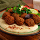 Healthy meal with falafel, tahini, salad, and drink on wooden table in cozy setting at lunchtime Healthy meal with falafel, tahini, salad, and drink on wooden table in cozy setting at lunchtime - PhotoDune Item for Sale