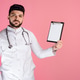 Brunette male doctor wearing uniform with phonendoscope, holding folder, showing. Brunette male doctor wearing uniform with phonendoscope, holding folder, showing. - PhotoDune Item for Sale