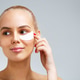 Portrait of a blonde woman applying undereye mask Portrait of a blonde woman applying undereye mask - PhotoDune Item for Sale